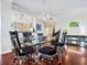 An inviting dining room with stylish seating, chandelier, and hardwood flooring at 5420 Eagles Point Cir # 106, Sarasota, FL 34231