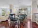 Elegant dining room with a glass-top table, wood floors, and custom cabinetry at 5420 Eagles Point Cir # 106, Sarasota, FL 34231