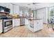 Bright kitchen features an island, stainless steel appliances, and ample white cabinetry at 5420 Eagles Point Cir # 106, Sarasota, FL 34231