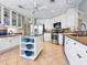 Bright kitchen features white cabinets, island with seating, and modern stainless steel appliances at 5420 Eagles Point Cir # 106, Sarasota, FL 34231
