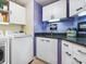 Efficient laundry room with modern washer and dryer, white cabinets, and a dark countertop at 5420 Eagles Point Cir # 106, Sarasota, FL 34231