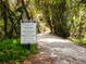 Nature trail entrance featuring signage with trail rules, including 'Closed Dusk to Dawn' at 5420 Eagles Point Cir # 106, Sarasota, FL 34231
