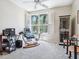 Bright office space with a large window, ceiling fan, glass desk, and modern furniture at 5420 Eagles Point Cir # 106, Sarasota, FL 34231