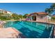 A community pool with clear blue water is in front of a community building with a red tiled roof at 5420 Eagles Point Cir # 106, Sarasota, FL 34231
