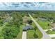 An aerial view showcases the home's location within a lush, green neighborhood and long driveway at 5482 Globe Ter, North Port, FL 34286