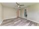 Bright bedroom with wood-look flooring and ceiling fan leading to ensuite bathroom at 5482 Globe Ter, North Port, FL 34286