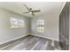 Bedroom featuring gray walls, wood-look floors, ceiling fan, and arched window at 5482 Globe Ter, North Port, FL 34286