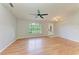 Inviting living room featuring hardwood floors, a ceiling fan, and ample natural light at 5482 Globe Ter, North Port, FL 34286