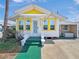 Charming home featuring a bright yellow accent, white siding, and a well-manicured green walkway at 55 Braden Castle Dr, Bradenton, FL 34208
