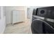 Well-organized laundry area featuring new appliances, storage cabinets, and wood-look flooring at 55 Braden Castle Dr, Bradenton, FL 34208