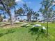 Outdoor picnic area with green grass, mature trees, picnic tables, and community homes in the background at 55 Braden Castle Dr, Bradenton, FL 34208