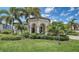 Beautifully landscaped front yard with mature palm trees and manicured bushes, offering curb appeal at 5622 Arnie Loop, Lakewood Ranch, FL 34211