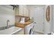 Efficient laundry room with front-load washer/dryer, granite counters, and ample cabinet space at 5622 Arnie Loop, Lakewood Ranch, FL 34211