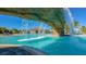 Relax under a waterfall in the community pool with an outdoor bar and palm trees in the distance at 5622 Arnie Loop, Lakewood Ranch, FL 34211