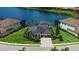 Beautiful aerial view of a home on the water featuring lush landscaping and a brick paved driveway at 5622 Arnie Loop, Lakewood Ranch, FL 34211