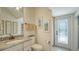 Bright bathroom featuring granite counters, framed beach art, and a glass paneled door to the outdoors at 5622 Arnie Loop, Lakewood Ranch, FL 34211