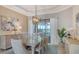 Bright dining room with modern chandelier and view of pool and lake at 5622 Arnie Loop, Lakewood Ranch, FL 34211