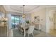 Beautiful dining room features modern chandelier, neutral color palette and view to the backyard at 5622 Arnie Loop, Lakewood Ranch, FL 34211