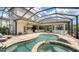 Lovely outdoor living space featuring a pool, spa, sun loungers, an outdoor kitchen and covered dining at 5622 Arnie Loop, Lakewood Ranch, FL 34211