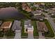 Stunning aerial view of a luxury home with a well-manicured yard, pool, and serene lake nearby at 5718 Title Row Dr, Bradenton, FL 34210