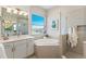 Bright bathroom with a soaking tub, shower, and white vanity, creating a spa-like experience at 5718 Title Row Dr, Bradenton, FL 34210