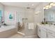 Luxurious bathroom with a soaking tub, glass-enclosed shower, and modern white vanity at 5718 Title Row Dr, Bradenton, FL 34210