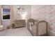 Charming Bedroom with floral wallpaper, wood crib, changing table, and soft pink accents at 5718 Title Row Dr, Bradenton, FL 34210