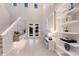 Bright entryway with double doors, high ceilings, decorative shelves and light-colored wood-look tile flooring at 5718 Title Row Dr, Bradenton, FL 34210