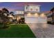 Beautiful two-story home with a three-car garage, lush lawn, and professionally landscaped front yard at 5718 Title Row Dr, Bradenton, FL 34210