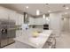 Modern kitchen with white cabinetry, stainless steel appliances, subway tile backsplash and island with barstool seating at 5718 Title Row Dr, Bradenton, FL 34210