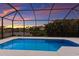 Inviting in-ground pool with screened enclosure overlooking a serene pond and sunset view at 5718 Title Row Dr, Bradenton, FL 34210