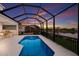 Stunning pool with lake view in a screened lanai, perfect for evening relaxation with beautiful sky views at 5718 Title Row Dr, Bradenton, FL 34210