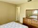 Bedroom featuring neutral walls, dresser with mirror, and a peek into the ensuite at 6110 Coral Way, Bradenton, FL 34207