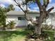 Exterior of home with neutral paint, simple landscaping, and mature tree at 6110 Coral Way, Bradenton, FL 34207