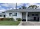 Charming home with green shutters, a covered carport, and well-maintained landscaping at 6110 Coral Way, Bradenton, FL 34207