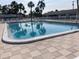 Outdoor community pool surrounded by lounge chairs and palm trees on a sunny day at 6110 Coral Way, Bradenton, FL 34207