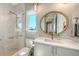 Modern bathroom features a glass shower, sleek vanity, and round mirror above sink at 612 Mourning Dove Dr, Sarasota, FL 34236