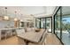 Elegant dining area with a long table, modern lighting, and access to the outdoor patio at 612 Mourning Dove Dr, Sarasota, FL 34236