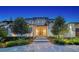 Inviting home exterior with manicured greenery, stone pathway, and warm lighting at 612 Mourning Dove Dr, Sarasota, FL 34236