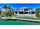 Luxury waterfront home with a private dock and pool, surrounded by lush tropical landscaping at 612 Mourning Dove Dr, Sarasota, FL 34236