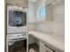 Efficient laundry room with stacked washer/dryer and countertop workspace at 612 Mourning Dove Dr, Sarasota, FL 34236