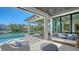 Covered patio with comfortable seating offering water views, overlooking the pool and waterway at 612 Mourning Dove Dr, Sarasota, FL 34236