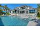 A stunning view of the backyard, showcasing a large swimming pool, spa, and elegant multi-level outdoor living space at 612 Mourning Dove Dr, Sarasota, FL 34236