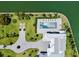 Aerial view of beautiful backyard featuring a pool, green lawn and a stone driveway at 630 De Narvaez Dr, Longboat Key, FL 34228