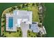 Aerial view of luxury estate highlighting pool, manicured landscaping, circular driveway, and waterfront boat dock at 630 De Narvaez Dr, Longboat Key, FL 34228