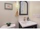 Half bath featuring a navy vanity with a decorative mirror and a shell-themed art print at 630 De Narvaez Dr, Longboat Key, FL 34228