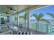A beautiful, covered outdoor deck features wicker furniture, ceiling fans, and stunning waterfront views at 630 De Narvaez Dr, Longboat Key, FL 34228