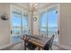Dining area with modern table and chairs, chandelier, and views of the balcony and water at 630 De Narvaez Dr, Longboat Key, FL 34228