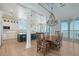 Elegant dining room with island kitchen, chandelier, and expansive water views at 630 De Narvaez Dr, Longboat Key, FL 34228