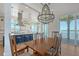 Open dining room with a wood table, chandelier, and views of the water and balcony at 630 De Narvaez Dr, Longboat Key, FL 34228
